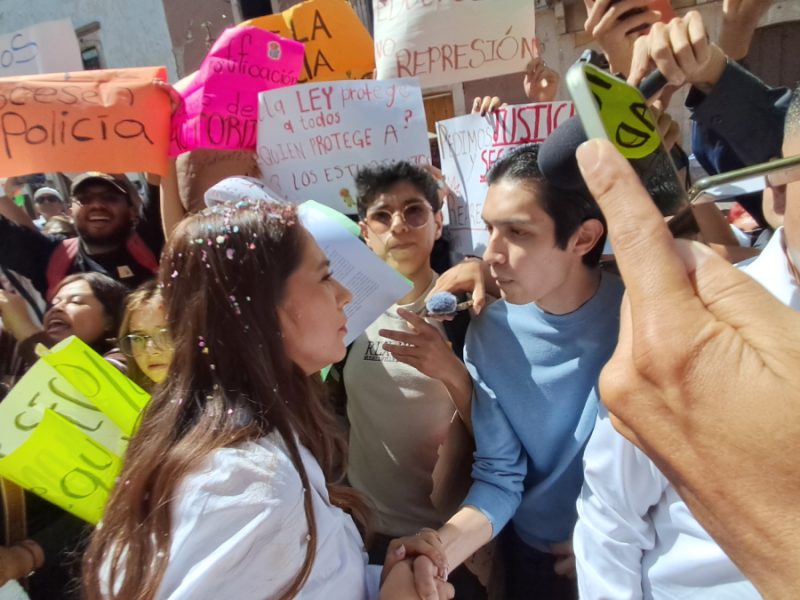 Alumnos de la UG irrumpen en desfile en Guanajuato y exigen justicia por presunto abuso policial